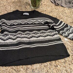 A black cute sweater that has really cute white pattern stripes